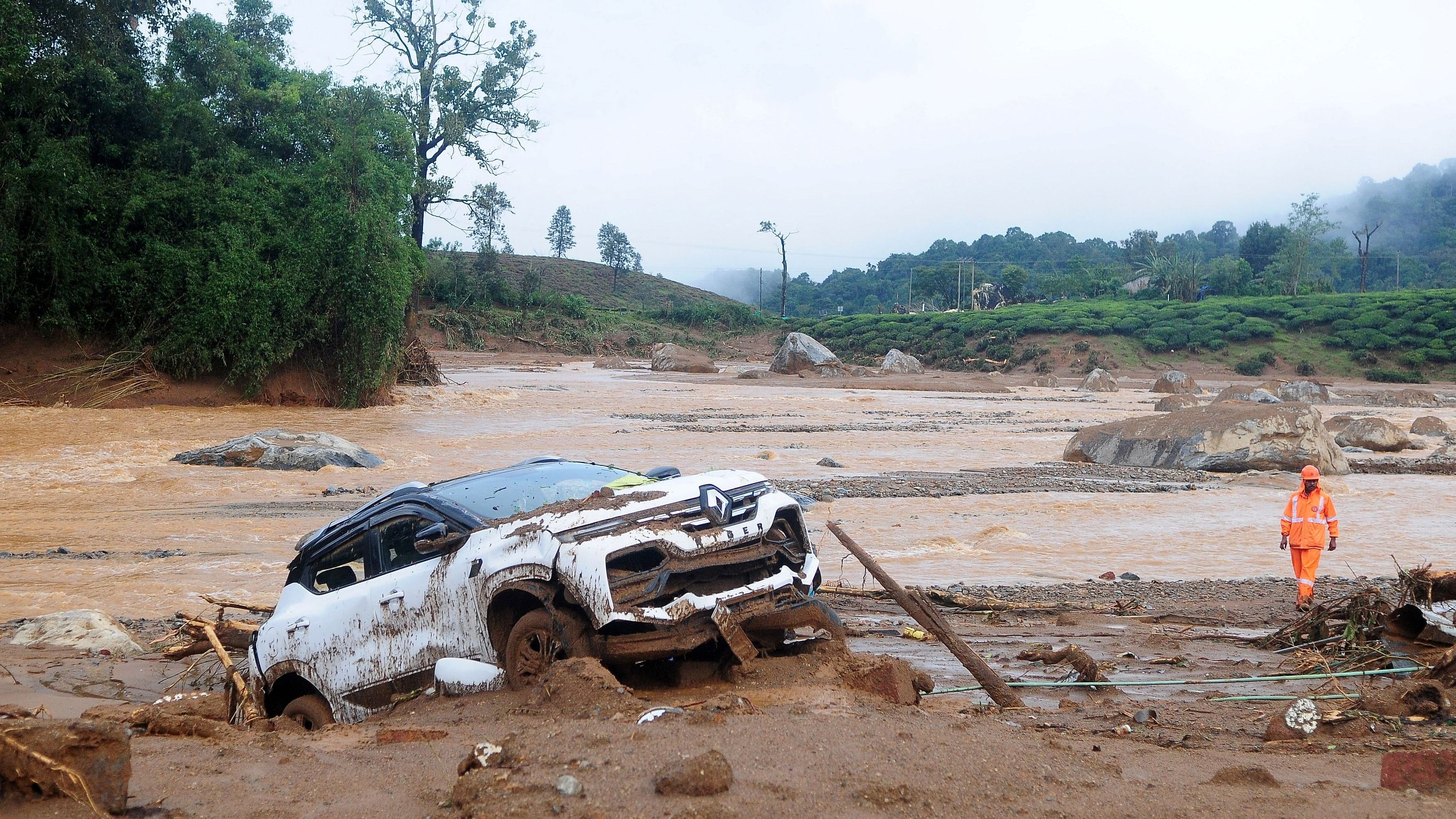 <div class="paragraphs"><p>A rescuer walks past a damaged car at a landslide site. Representative image.</p></div>